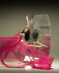 Image showing Young and stylish modern ballet dancer on brown background