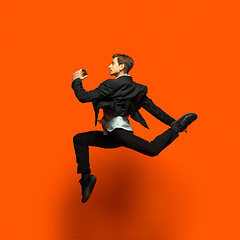 Image showing Man in casual office style clothes jumping isolated on studio background