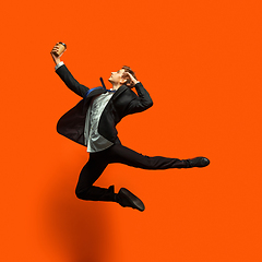 Image showing Man in casual office style clothes jumping isolated on studio background