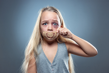 Image showing Sad and frightened little girl with bloodshot and bruised eyes, fiction of happiness