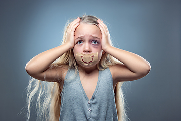 Image showing Sad and frightened little girl with bloodshot and bruised eyes, fiction of happiness