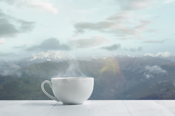 Image showing Single tea or coffee mug and landscape of mountains on background