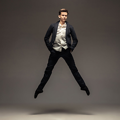 Image showing Man in casual office style clothes jumping isolated on studio background