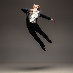 Image showing Man in casual office style clothes jumping isolated on studio background