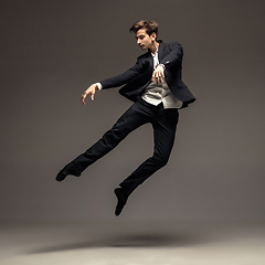 Image showing Man in casual office style clothes jumping isolated on studio background