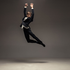 Image showing Man in casual office style clothes jumping isolated on studio background