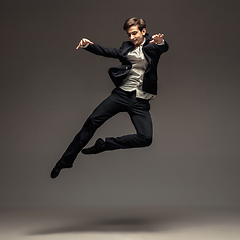 Image showing Man in casual office style clothes jumping isolated on studio background