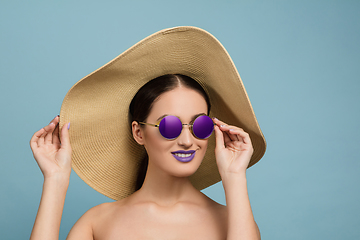 Image showing Portrait of beautiful young woman with bright make-up isolated on blue studio background