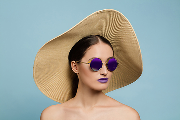 Image showing Portrait of beautiful young woman with bright make-up isolated on blue studio background