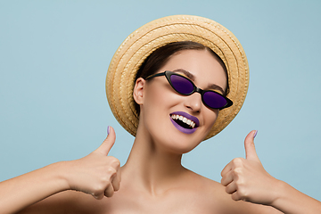 Image showing Portrait of beautiful young woman with bright make-up isolated on blue studio background