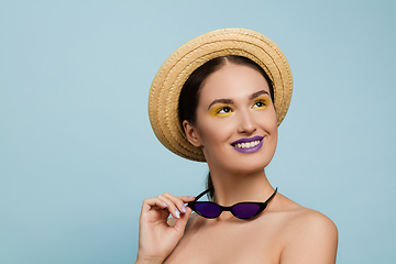 Image showing Portrait of beautiful young woman with bright make-up isolated on blue studio background