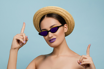 Image showing Portrait of beautiful young woman with bright make-up isolated on blue studio background