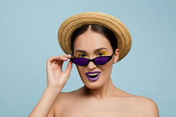 Image showing Portrait of beautiful young woman with bright make-up isolated on blue studio background