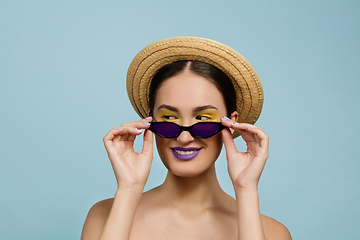 Image showing Portrait of beautiful young woman with bright make-up isolated on blue studio background