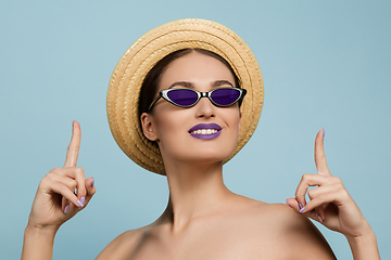 Image showing Portrait of beautiful young woman with bright make-up isolated on blue studio background