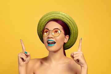 Image showing Portrait of beautiful young woman with bright make-up isolated on yellow studio background