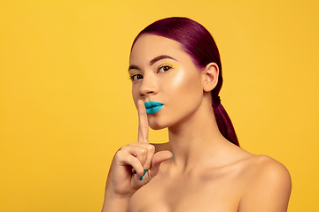 Image showing Portrait of beautiful young woman with bright make-up isolated on yellow studio background