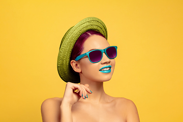 Image showing Portrait of beautiful young woman with bright make-up isolated on yellow studio background