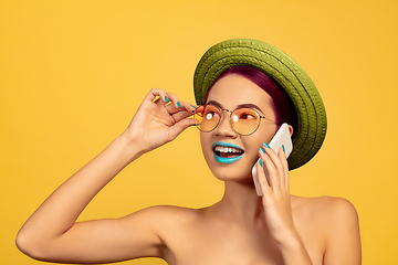 Image showing Portrait of beautiful young woman with bright make-up isolated on yellow studio background