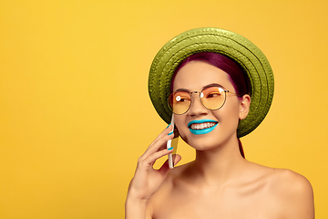 Image showing Portrait of beautiful young woman with bright make-up isolated on yellow studio background