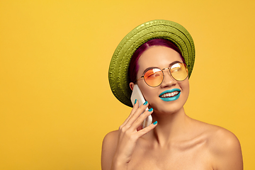 Image showing Portrait of beautiful young woman with bright make-up isolated on yellow studio background