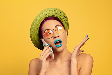 Image showing Portrait of beautiful young woman with bright make-up isolated on yellow studio background