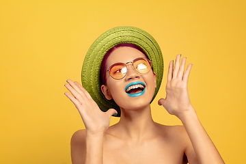 Image showing Portrait of beautiful young woman with bright make-up isolated on yellow studio background