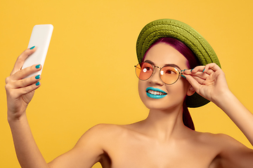 Image showing Portrait of beautiful young woman with bright make-up isolated on yellow studio background