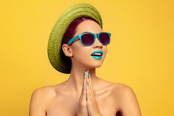 Image showing Portrait of beautiful young woman with bright make-up isolated on yellow studio background