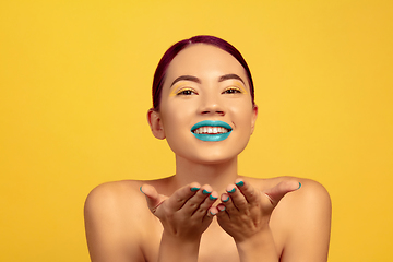 Image showing Portrait of beautiful young woman with bright make-up isolated on yellow studio background
