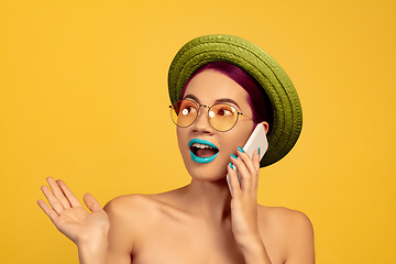 Image showing Portrait of beautiful young woman with bright make-up isolated on yellow studio background