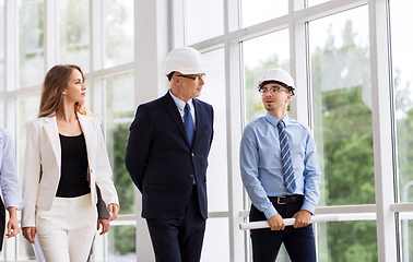 Image showing business team in helmets walking along office