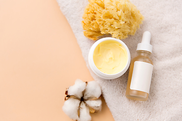 Image showing body butter, essential oil, sponge on bath towel