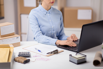 Image showing woman with laptop and clipboard at post office