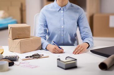 Image showing close up of woman filling postal form at office