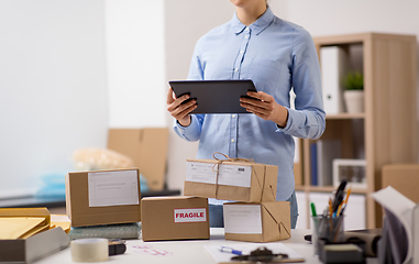 Image showing woman with tablet pc and parcels at post office