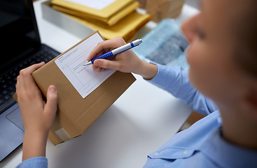 Image showing close up of woman filling postal form at office