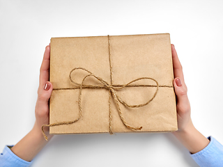 Image showing hands with parcel box tied by rope at post office