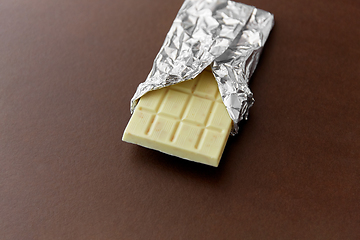 Image showing white chocolate bar in foil wrapper on brown