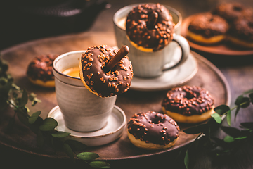 Image showing Coffee time - two cups of Caffe Americano with small chocolate donuts