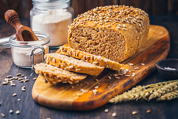 Image showing Homemade wholemeal spelt bread with sunflower seeds and baking ingredients