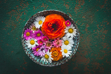 Image showing Variation of flowers in bowl on green background