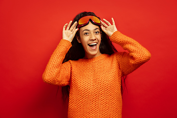 Image showing African-american young woman\'s portrait in ski mask on red background