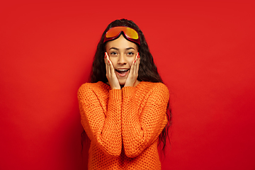 Image showing African-american young woman\'s portrait in ski mask on red background