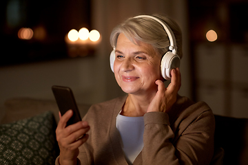 Image showing senior woman in headphones listening to music