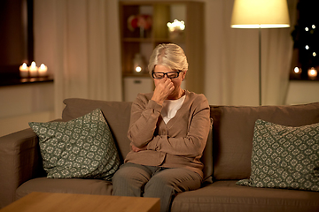 Image showing tired senior woman in glasses at home at night