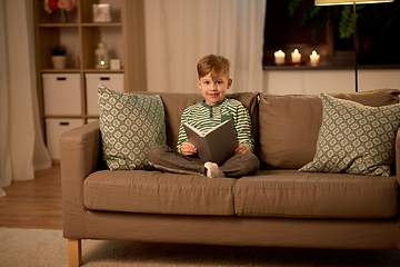 Image showing happy little boy reading book at home