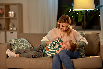 Image showing happy mother with sleeping little son at home