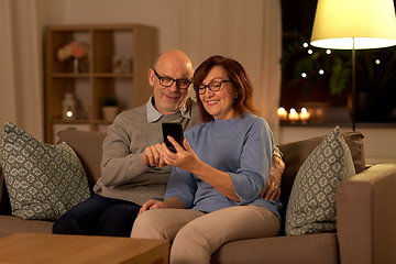 Image showing happy senior couple with smartphone at home