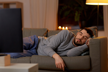 Image showing man sleeping on sofa with tv remote at home